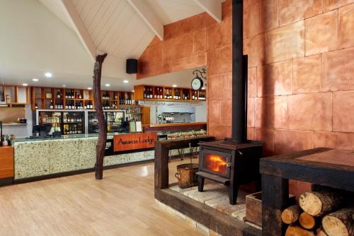 a restaurant with a wood stove in a room at Awaroa Lodge in Awa-iti