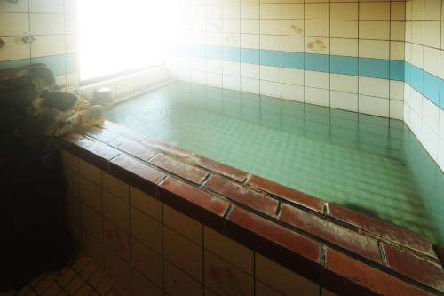 een badkamer met een bad gevuld met water bij SPA Inn Shirahama in Shirahama
