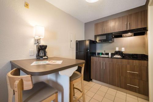 a small kitchen with a counter and a refrigerator at Studio 6-Duluth, GA - Atlanta - Gwinnett Place in Duluth