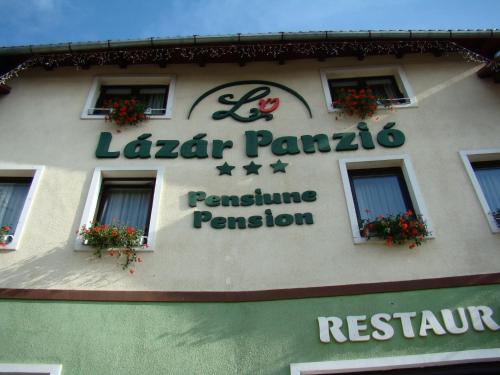 a sign for a restaurant on the side of a building at Lázár Pension & Restaurant in Gheorgheni