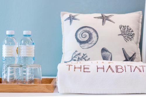 two bottles of water on a tray next to a pillow at THE HABITAT Koh Chang - VJ Island View in Ko Chang