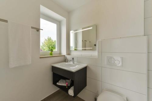 a white bathroom with a sink and a mirror at Maiers Hotel Parsberg in Parsberg