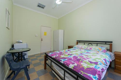 a bedroom with a bed and a table and a chair at Victoria Park Lodge in Perth