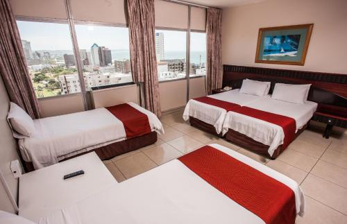 Habitación de hotel con 2 camas y ventana en Coastlands Durban Self Catering Holiday Apartments en Durban