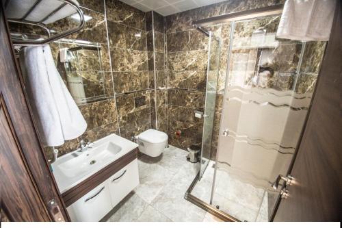 a bathroom with a shower and a sink and a toilet at The Corner Hotel in Sincan