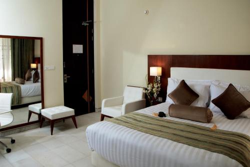 a hotel room with a large bed and a chair at Avari Boutique Multan in Multan