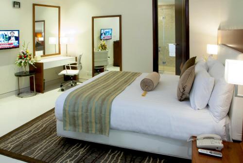 a hotel room with a large bed and a desk at Avari Boutique Multan in Multan