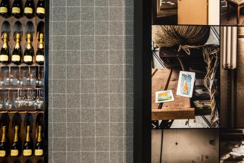a wine cellar with a shelf of wine bottles at L'Imprimerie Hôtel in Clichy
