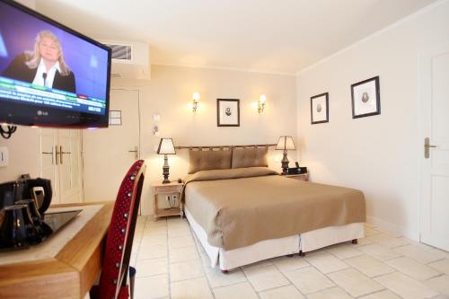 a bedroom with a bed and a flat screen tv at Hotel Albe Bastille in Paris