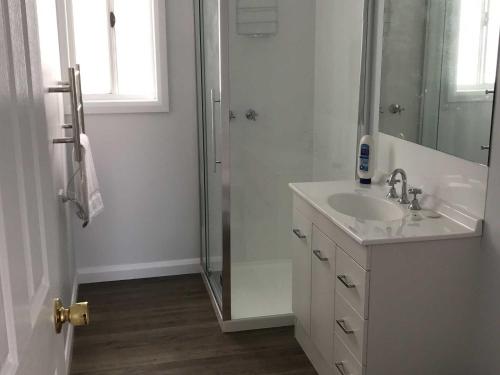 a white bathroom with a sink and a shower at Derby Digs Cottage in Derby