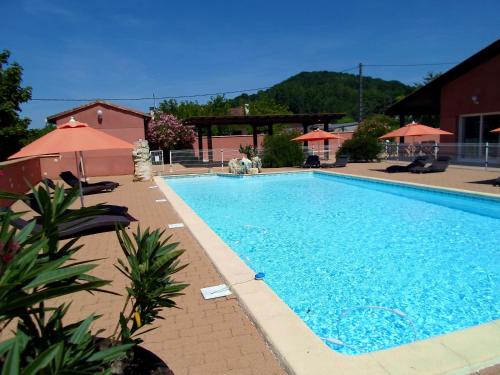 ein großer blauer Pool mit Stühlen und Sonnenschirmen in der Unterkunft Cit'Hôtel- Hôtel d'Occitanie in Pont-du-Casse