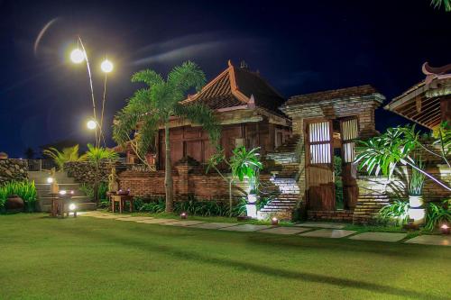 een houten huis 's nachts met een straatlicht bij Rumah Tembi in Yogyakarta