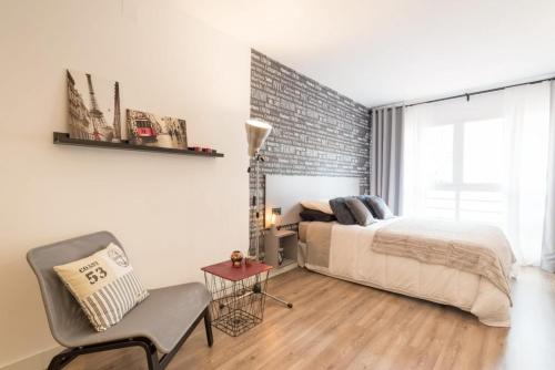 a bedroom with a bed and a brick wall at Malagueta Beach Studio in Málaga