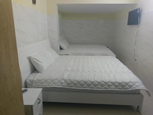 1 dormitorio pequeño con 1 cama con sábanas blancas en ST. Dong Tam Guesthouse en Dalat