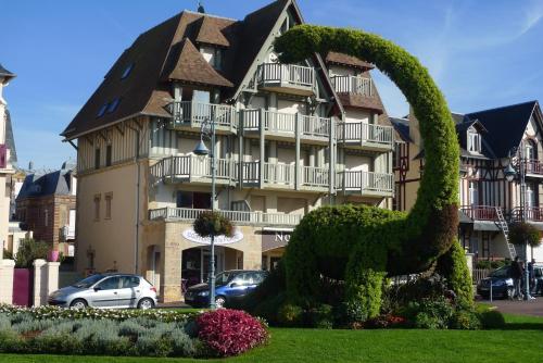 un bâtiment avec une statue devant lui dans l'établissement Plazza front de Mer, à Villers-sur-Mer