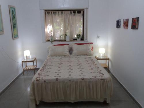 a bedroom with a large bed with two lamps at Zipi Orhan in Acre