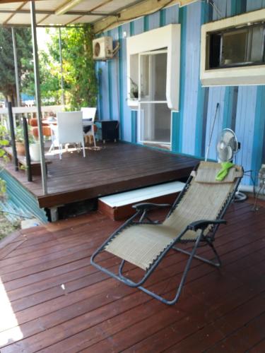 una silla en una terraza con una mesa y un banco en Zipi Orhan, en Acre