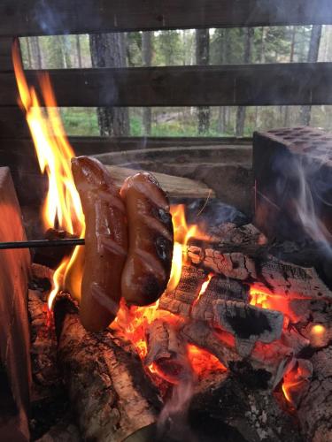 dwa hot dogi pieką się nad ogniskiem w obiekcie Levinlento w mieście Levi