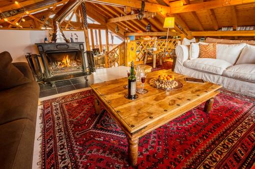 - un salon avec une table en bois et une cheminée dans l'établissement La Portette Chambres d'Hôtes, à Bellentre