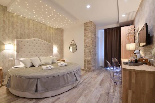 a bedroom with a large bed and a kitchen at Veneto Suite Rome in Rome