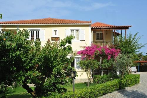 a house with pink flowers in front of it at Fiore Hill Sea View Studios in Vasilikos