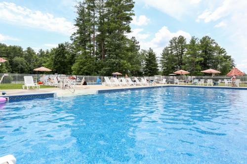 una gran piscina con sillas y sombrillas en Tuxbury Pond Camping Resort Tiny House Emerson, en South Hampton