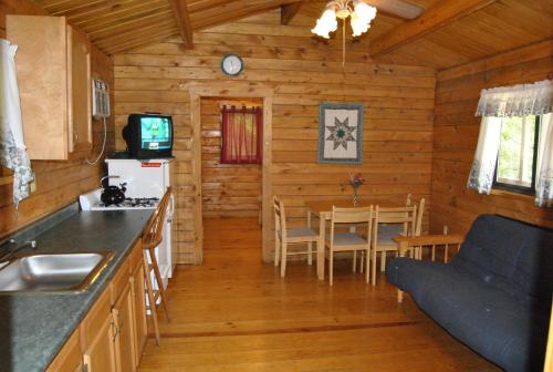 eine Küche und ein Esszimmer eines Blockhauses in der Unterkunft Robin Hill Camping Resort Two-Bedroom Cottage 6 in Lenhartsville