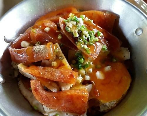 un bol de nourriture avec des légumes et de la sauce dans l'établissement Bansuanrachawadee B&b, à Si Saket