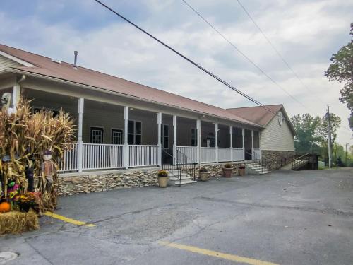 un edificio más antiguo con una valla blanca y un edificio en Appalachian Camping Resort Cottage 1, en Shartlesville
