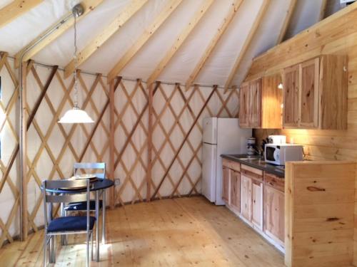 eine Küche in einem Zelt mit einem Tisch und einem Kühlschrank in der Unterkunft Circle M Camping Resort 16 ft. Yurt 1 in Lancaster