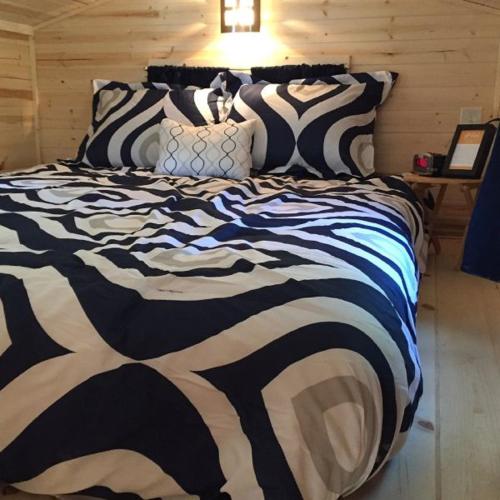 a large bed with a black and white comforter at Leavenworth Camping Resort Tiny House Otto in Leavenworth