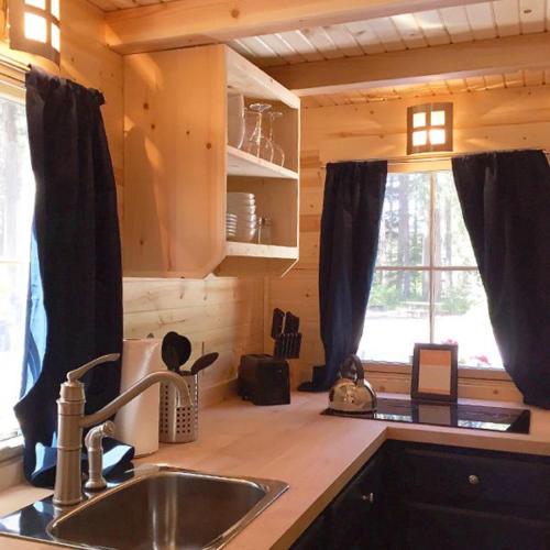 a kitchen with a sink and a window in a cabin at Leavenworth Camping Resort Tiny House Otto in Leavenworth