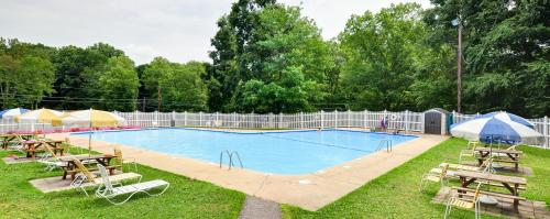 a large swimming pool with tables and chairs around it at Sun Valley Campground Cottage 4 in Maple Grove Park