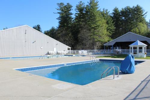 an empty swimming pool with a building in the background at Tuxbury Pond Camping Resort Tiny House Murphy in South Hampton