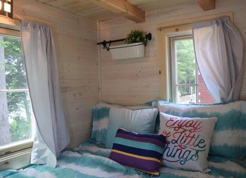 En eller flere senge i et værelse på Tuxbury Pond Camping Resort Tiny House Riley