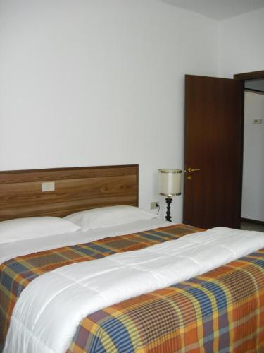洛韋雷的住宿－格拉茲拉度假屋，一间卧室配有一张带条纹毯子的大床