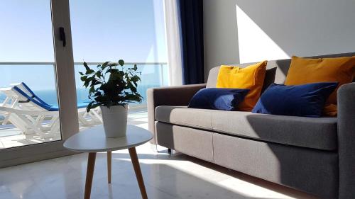 uma sala de estar com um sofá e uma mesa com uma planta em Luxury Penthouse on the 42nd floor with amazing sea views em Benidorm