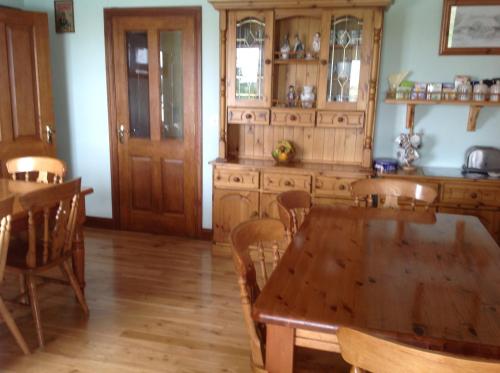 a kitchen with a wooden table and wooden cabinets at The Rock Equestrian Farm B&B in Bailieborough