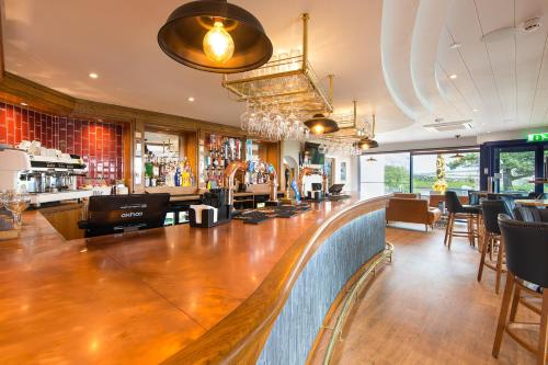 a bar with a long wooden counter in a restaurant at Gwesty Gadlys Hotel in Cemaes Bay