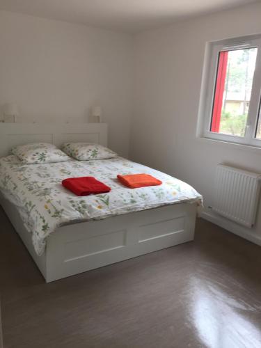 Una cama blanca con dos toallas rojas. en Villa Coquelicot en Lacanau