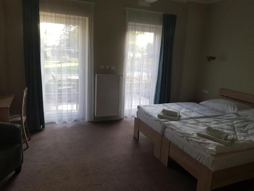 a bedroom with a bed and two large windows at Statek 1738 in Všestudy