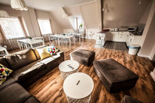 ein Wohnzimmer mit einem Sofa und Tischen sowie eine Küche in der Unterkunft Bi-Pi Hostel in Danzig