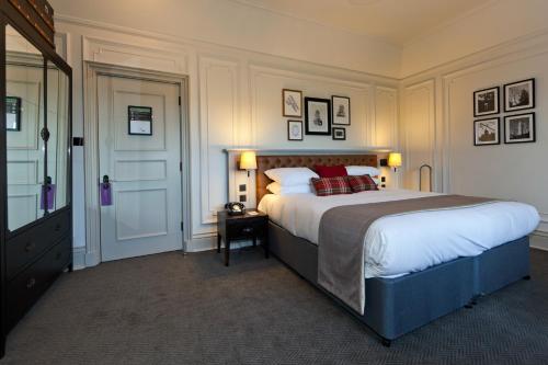 a bedroom with a large bed with red pillows at De Vere Horsley Estate in Leatherhead