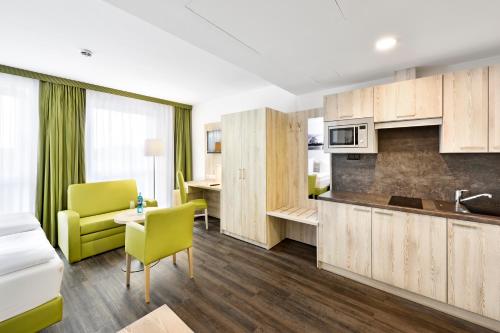 ein Wohnzimmer mit einer Küche und einem Esszimmer in der Unterkunft Novina Sleep Inn Herzogenaurach in Herzogenaurach