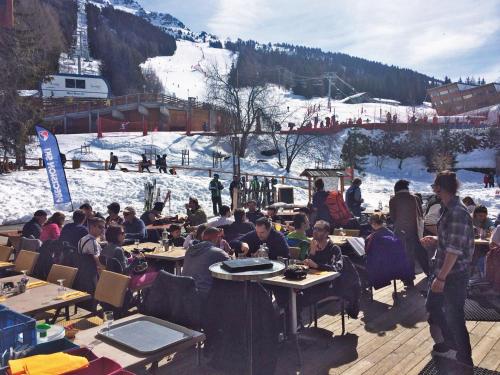 a group of people sitting at tables at a ski resort at Lagrange Vacances Le Roc Belle Face in Arc 1600
