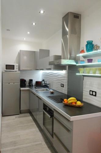 une cuisine avec un bol de fruits sur le comptoir dans l'établissement Carré d'or Very nice appart Near the beach, à Nice