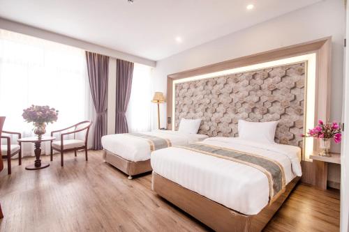 a hotel room with two beds and a stone wall at New York Hotel in Phnom Penh