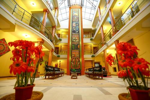 a lobby with red flowers in vases in a building at Hotel Abi's Inn in Thanjāvūr