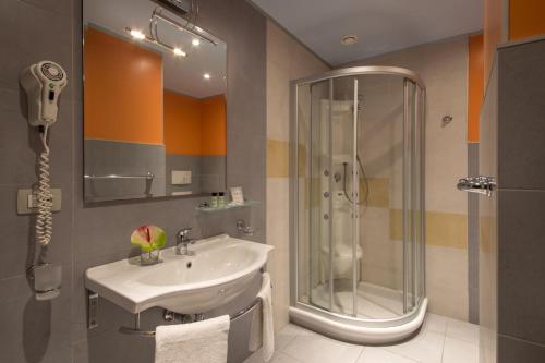 a bathroom with a sink and a shower at Hotel Mediterraneo in Livorno