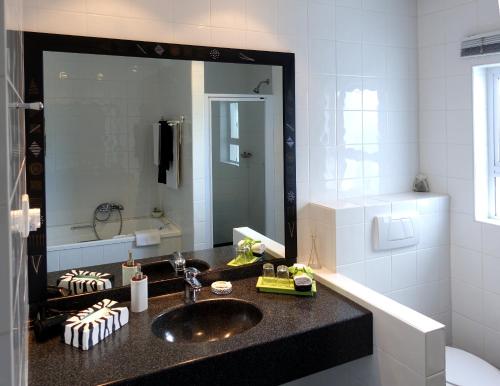 a bathroom with a sink and a large mirror at Cintsa Lodge in Chintsa